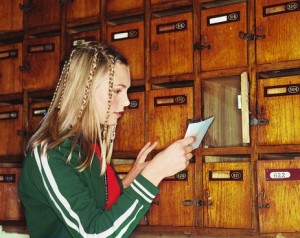 teenage girl reading note taken from her mailbox