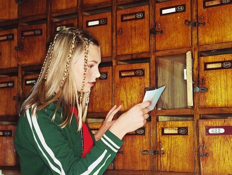 teenage girl reading note taken from her mailbox